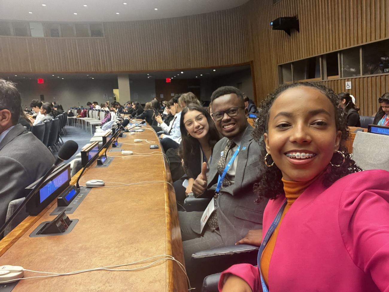 Antonia Mella junto a delegados representantes de otros países sentados en un plenario de la Sede de Naciones Unidas