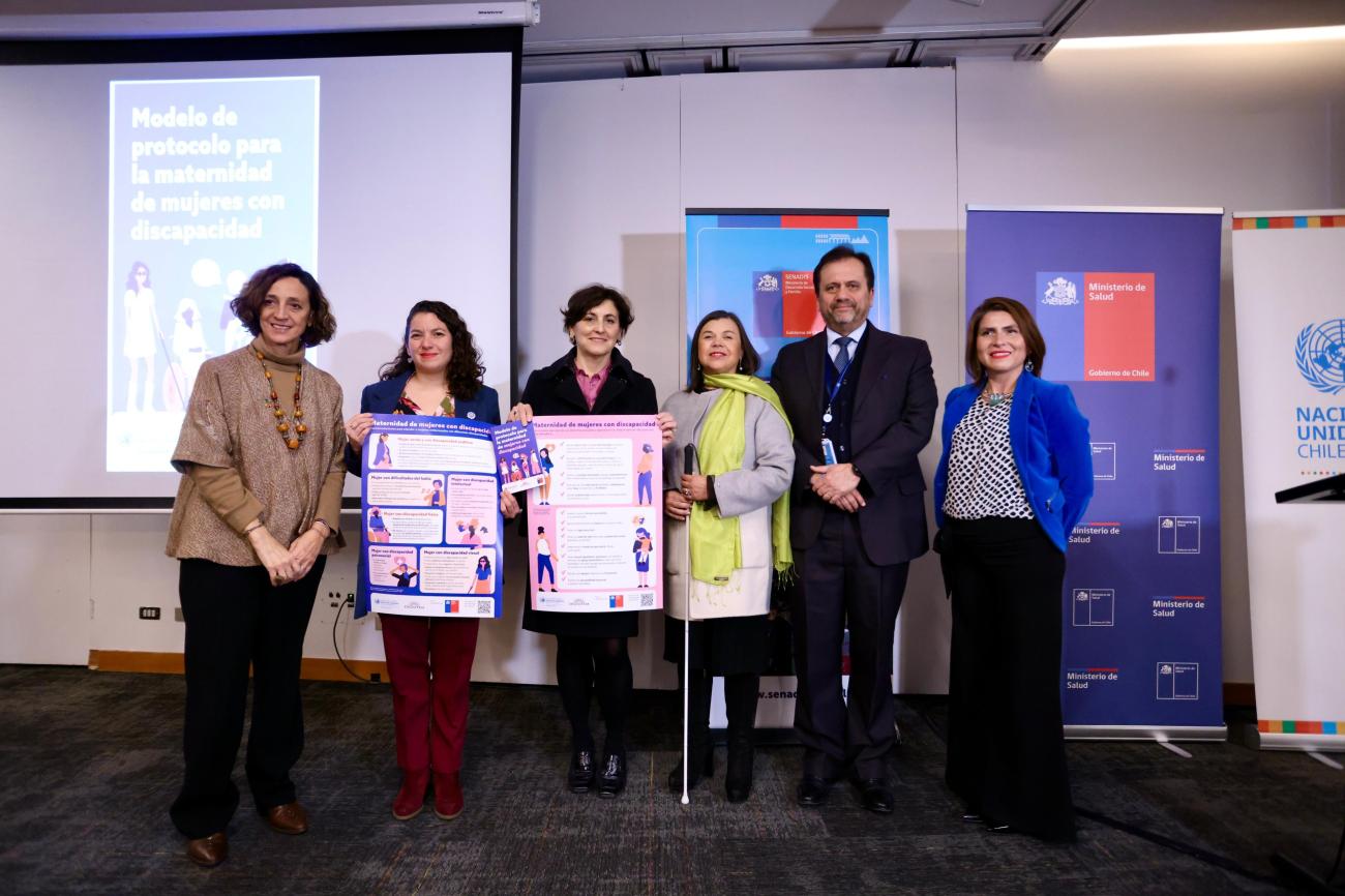 autoridades de Naciones Unidas y del Gobierno posan con el afiche y el librillo entregado durante la entrega del protocolo