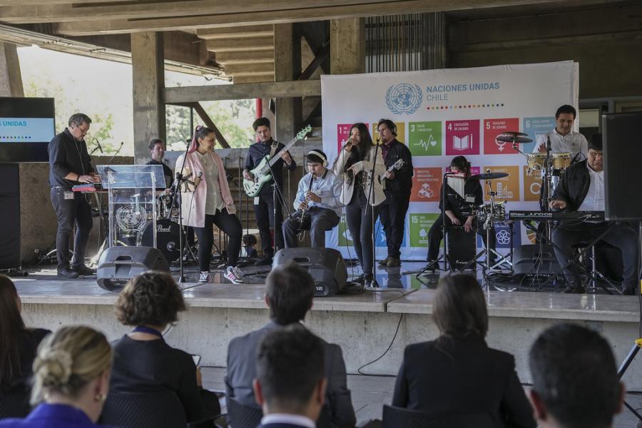 Presentación de los músicos de la Orquesta Eleva en el escenario, con autoridades y concurrentes mirando la presentación